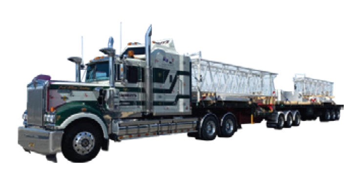 A large green and white semi-truck with chrome details is hauling a long flatbed trailer carrying metal framework structures.